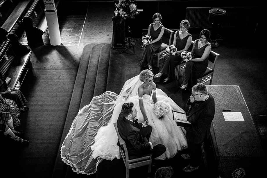 A Bride And Groom And Bridesmaids Seated At St Peters & St Andrews Church During A Wedding Ceremony