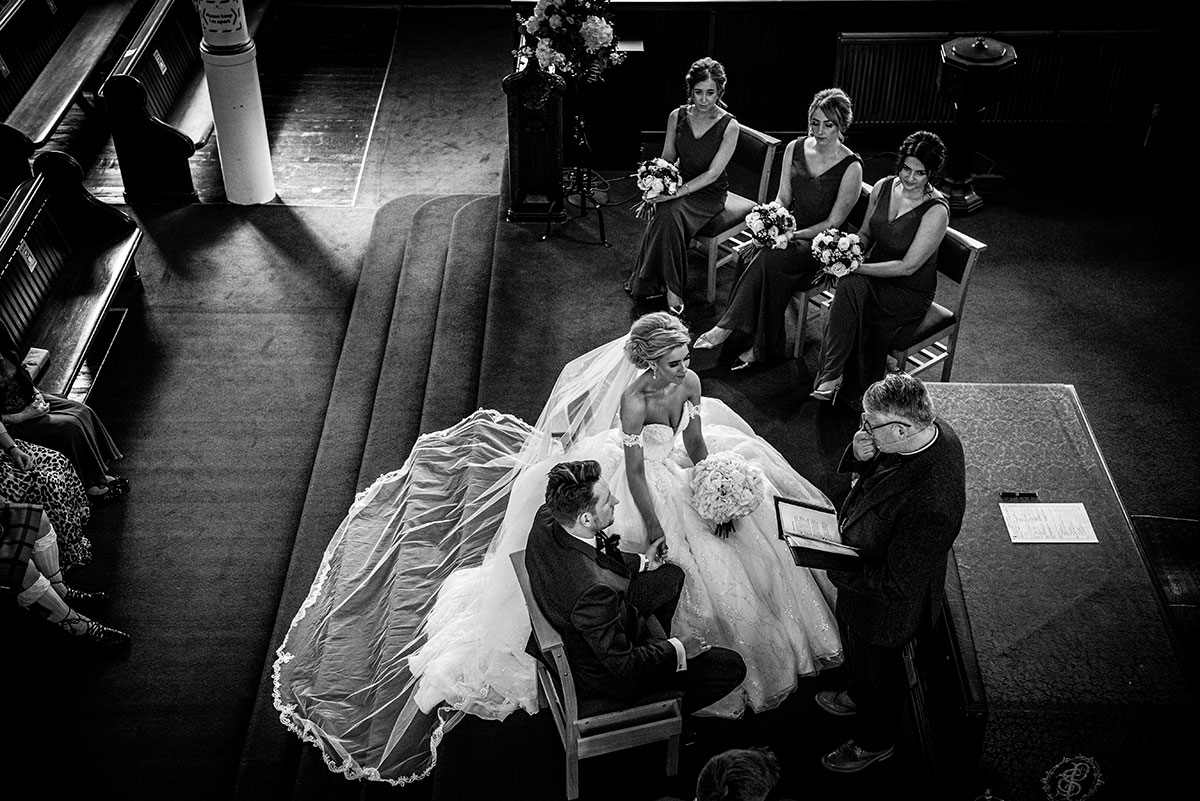 A Bride And Groom And Bridesmaids Seated At St Peters & St Andrews Church During A Wedding Ceremony