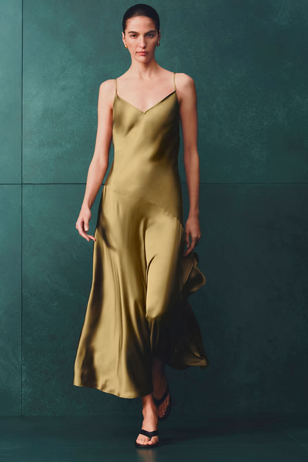 Olive green satin slip dress with bias cut silhouette styled in a minimalist studio setting