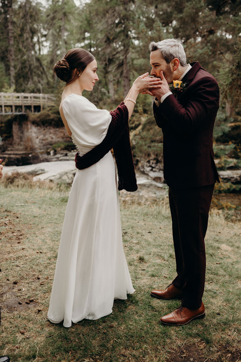 Outdoor wedding ceremony with whisky in quaich ritual on River Quoich at Mar Lodge Estate