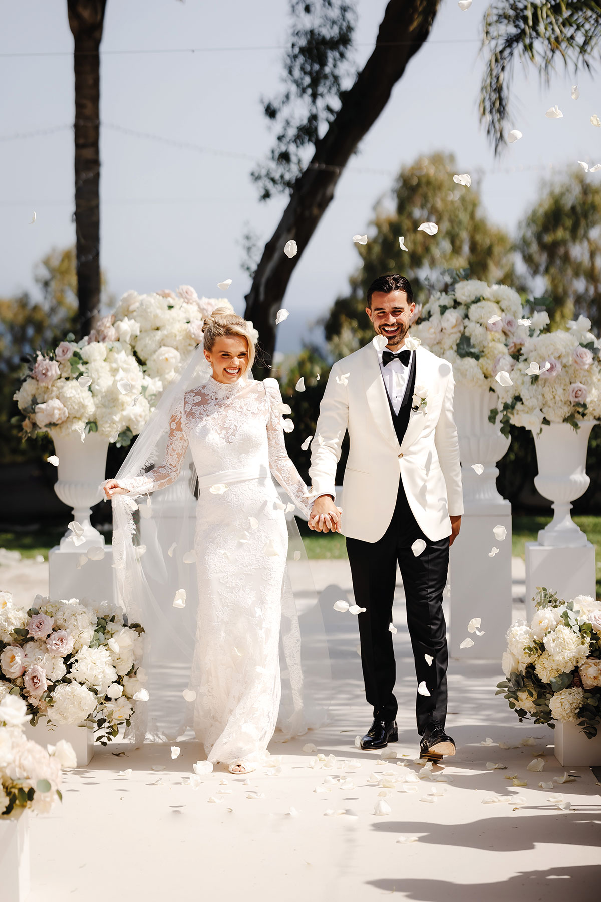 bride and groom smile in marbella as guests through confetti over them on wedding day