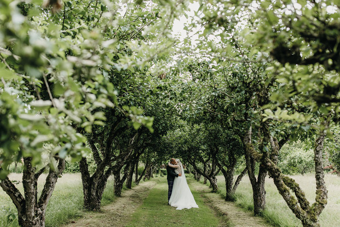 bride and groom kiss under tree archway at wedding at byre at inchyra
