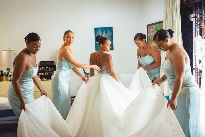 Leigh Anne Pinnock and her four bridesmaids helping her into her dress