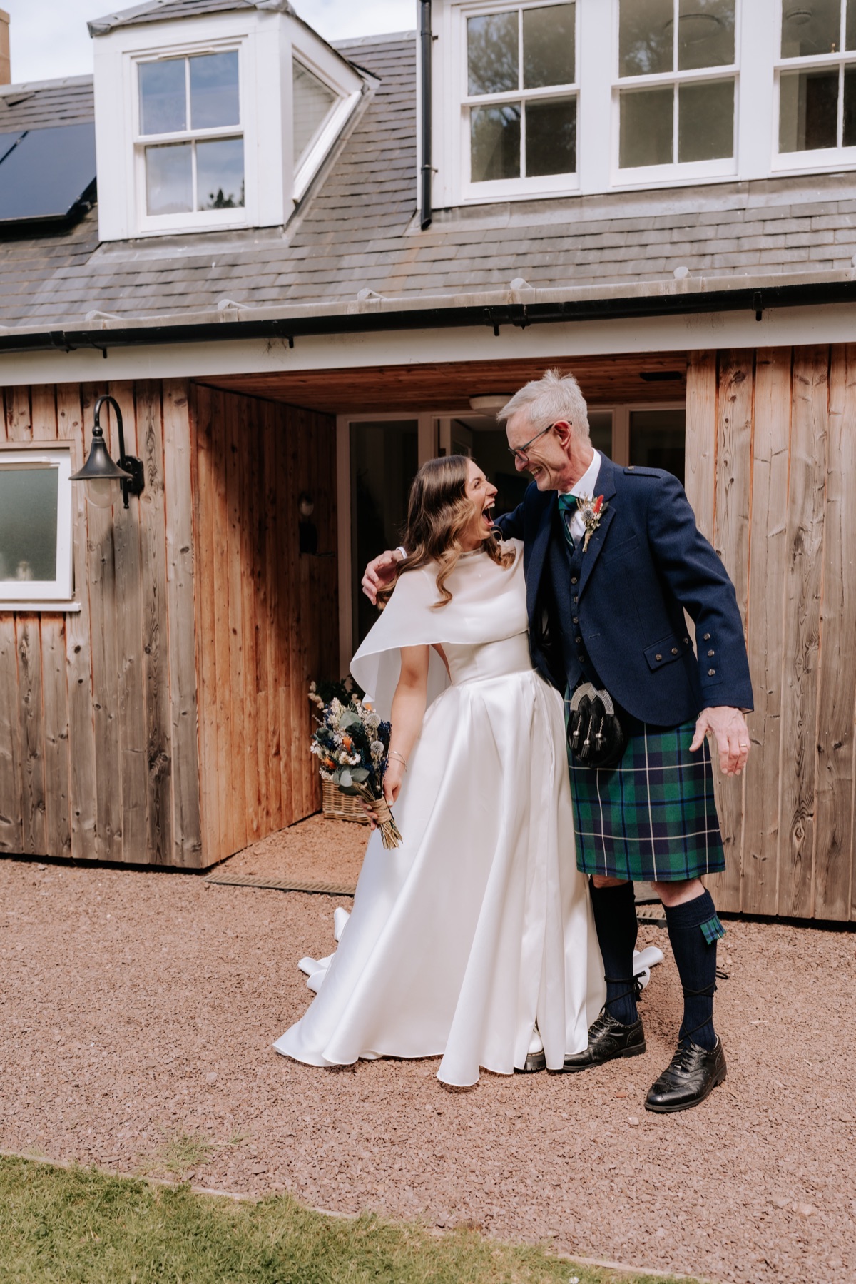 Bride sharing a laugh with a man wearing a kilt before the wedding ceremony at Harvest Moon.