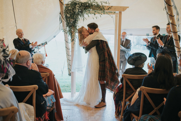 The couple share a kiss at the top of the aisle