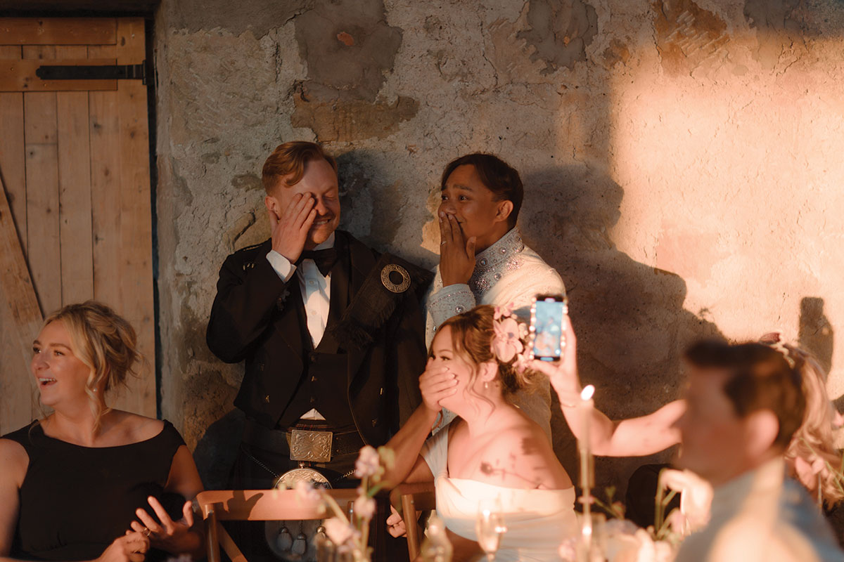 Emotional moment as grooms watch surprise choir perform during barn wedding reception at Falkirk farm
