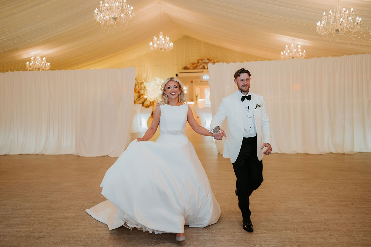 Bride and groom entering marquee reception at Ingliston Country Club wedding