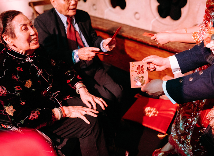 a hand presenting an embossed card to a seated person