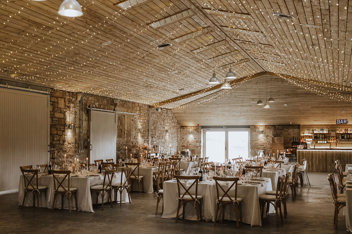 tables set up with chairs and fairylights for wedding at falside mill