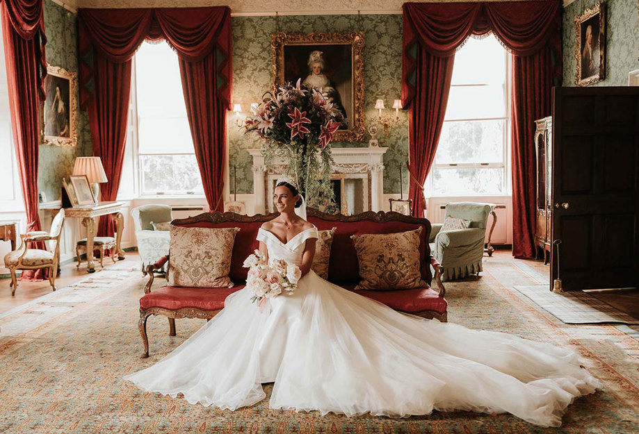 bride sits down in large wedding dress in historical room at fyvie castle
