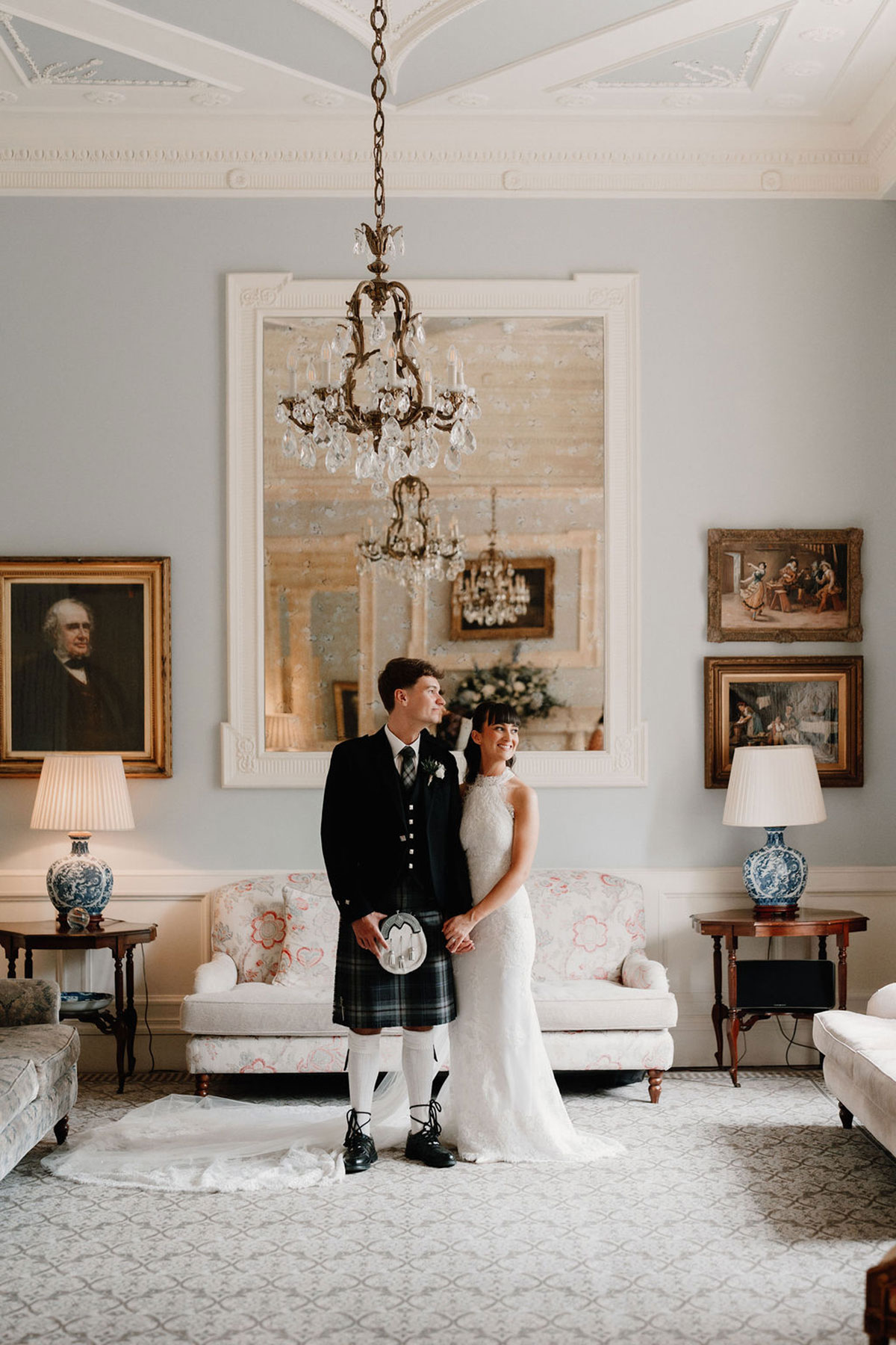 Bride and groom posing in the grand drawing room at Crossbasket Castle during their Scottish wedding