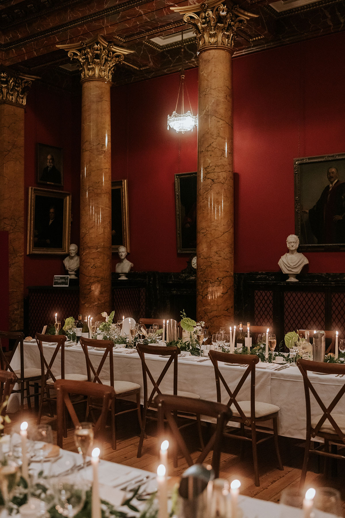 Candlelit wedding dinner setup with long tables, white linens, and floral décor.