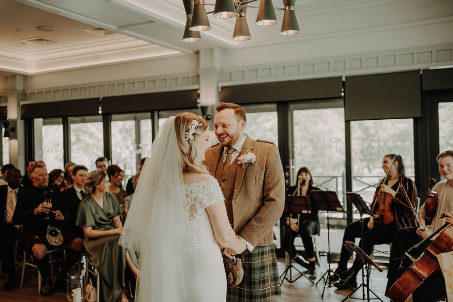 Bride and groom hold hands during the ceremony