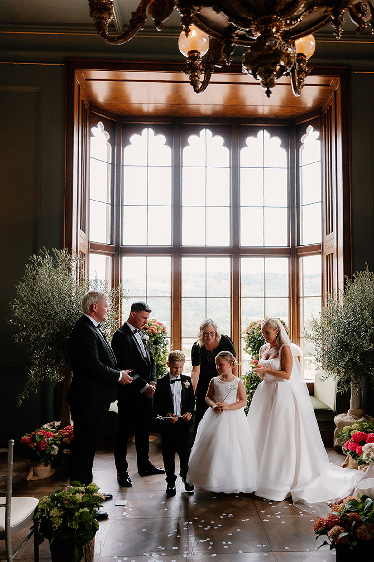 Family gathered at the front during the wedding ceremony at Mar Hall with children participating.