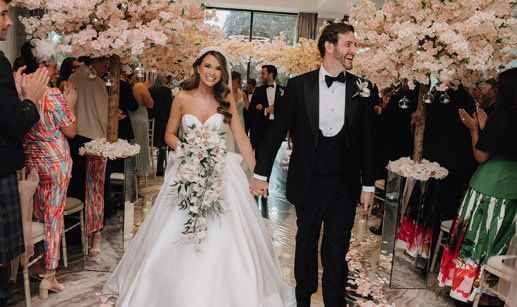 a bride and groom walking up the aisle at Cameron House with cherry blossom trees either side.