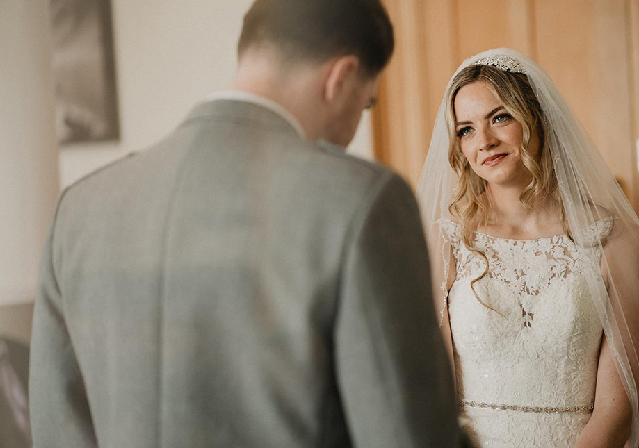 bride looking at groom lovingly at the top of the aisle