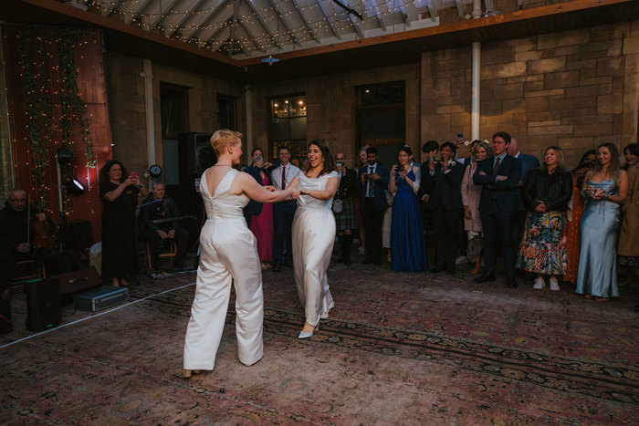 two brides dance at wedding reception at cambo house and estate wearing custom made outfits 