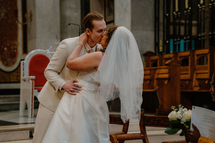 Bride and groom kissing during ceremony in St Aloysius Church