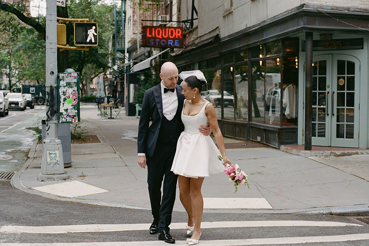 Bride and groom walking across Manhattan crosswalk together after New York City Hall wedding