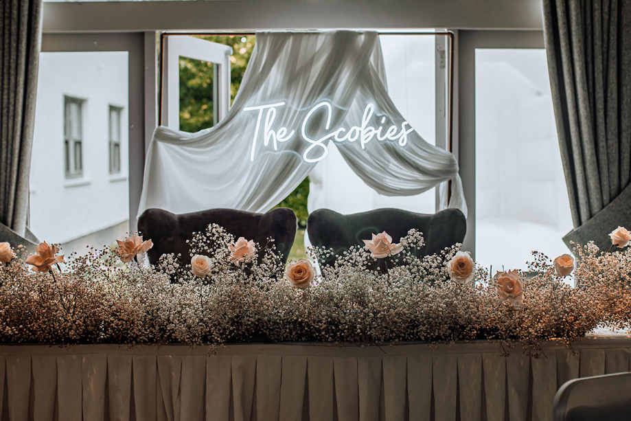 Top table with pink foliage and neon sign