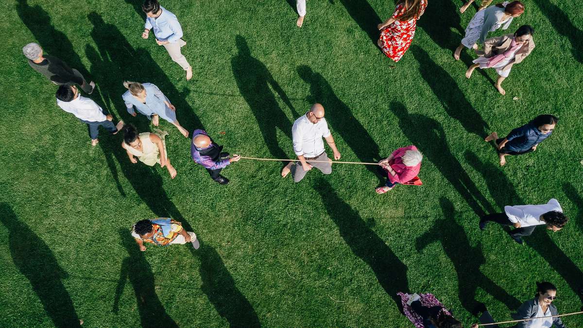 Overhead drone photograph of wedding guests playing tug of war on the lawn at Ardoch Loch Lomond