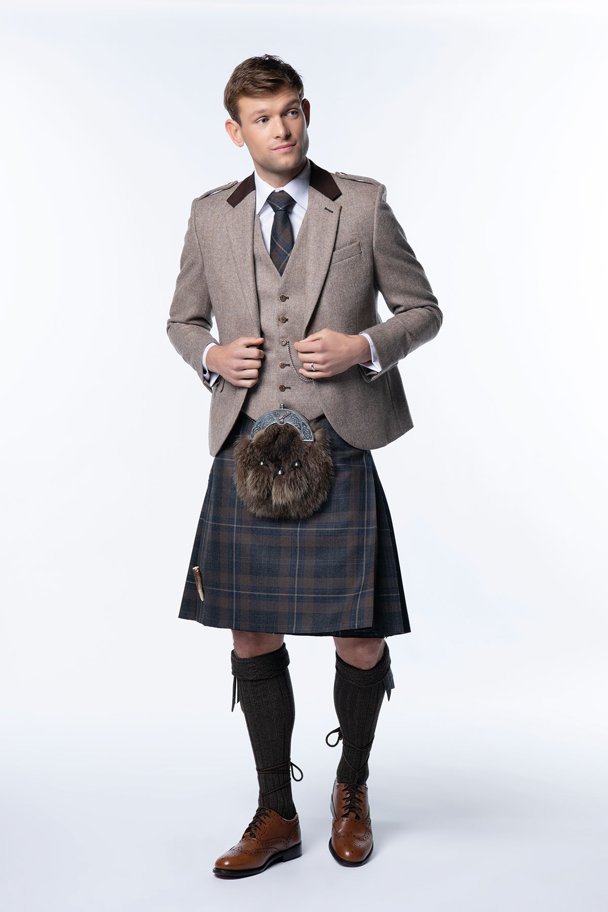 Groom wearing a brown tweed jacket, tartan kilt and sporran for a traditional Scottish wedding outfit