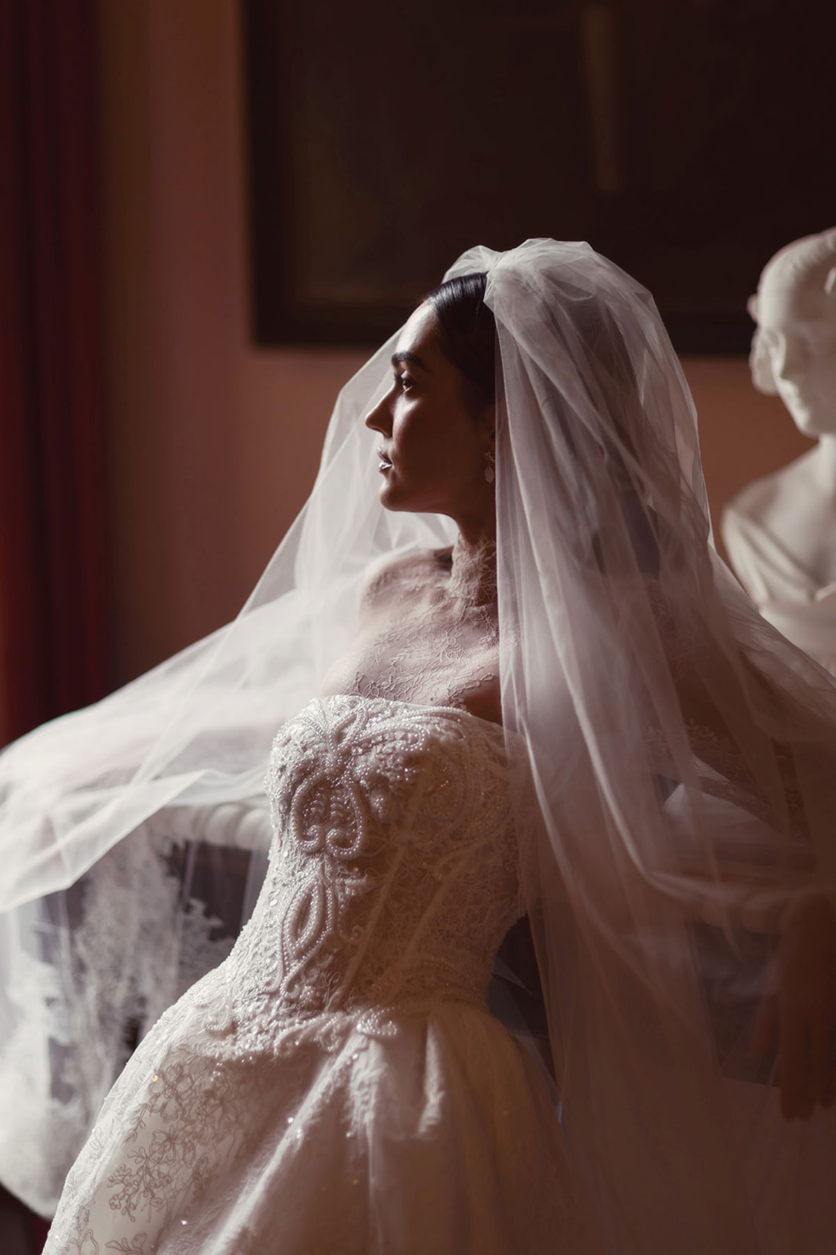Moody bridal portrait with a soft veil and lace wedding dress inside Gosford House.