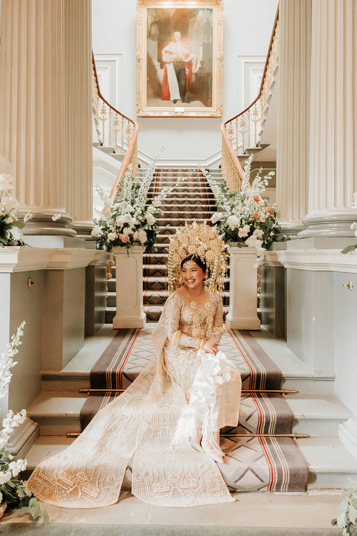 bride sitting on steps at signet library in edinburgh wearing embroidered ceremony cape