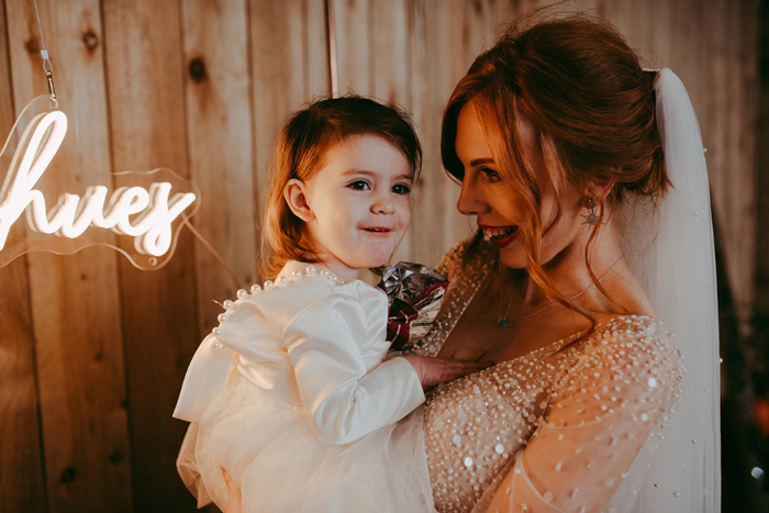 Bride holding her daughter by Pocket Square Photography