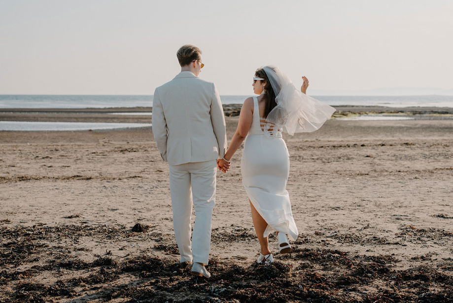Bride walk hand in hand on Troon beach