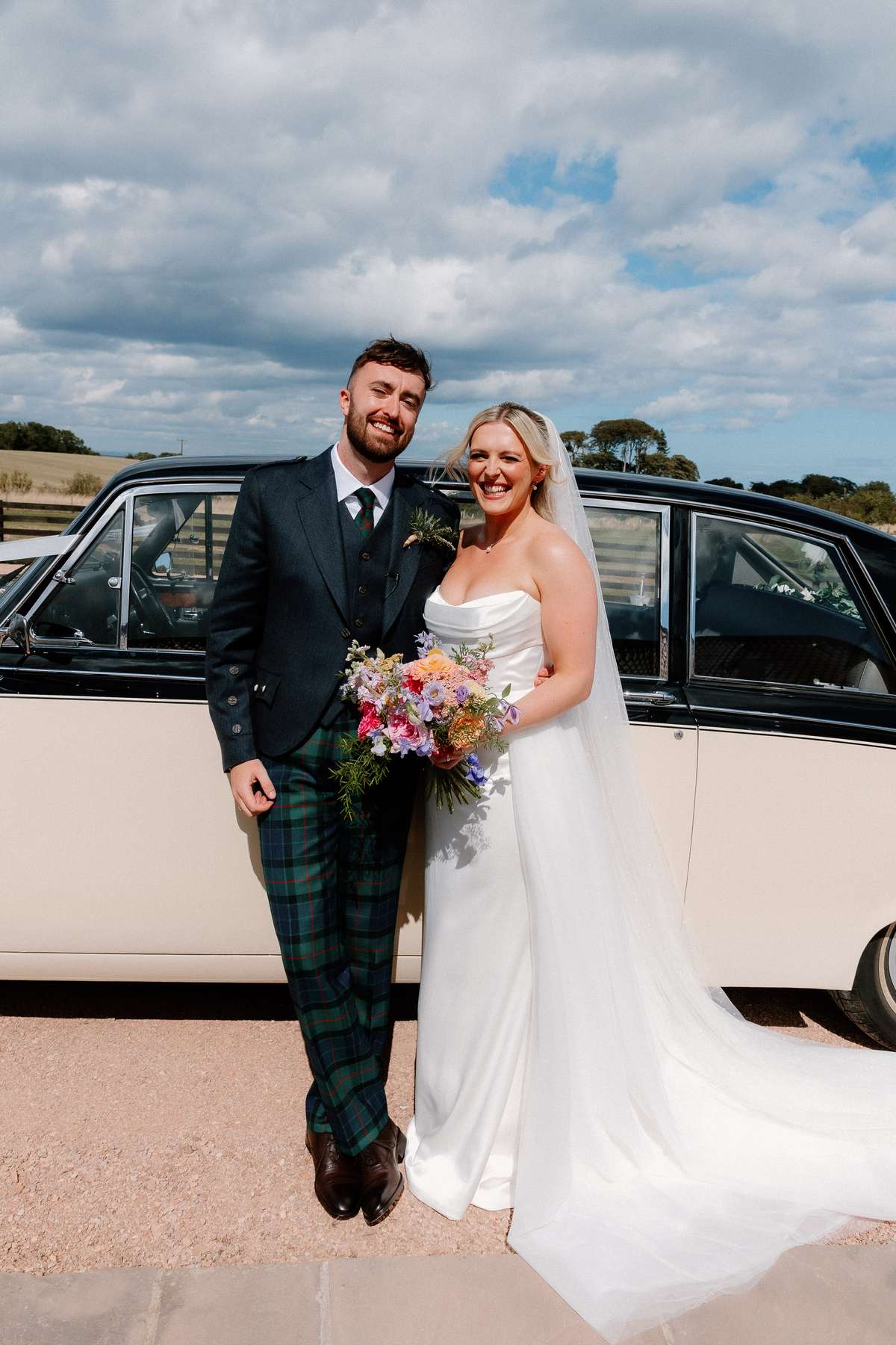 Bride and groom portrait beside a vintage wedding car at Falside Mill wedding venue in Fife