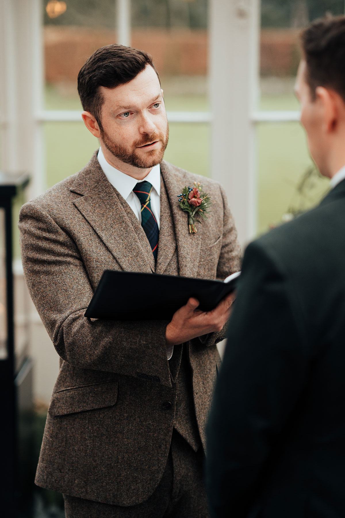 Groom reading from a vow book during the ceremony at Schloss Roxburghe
