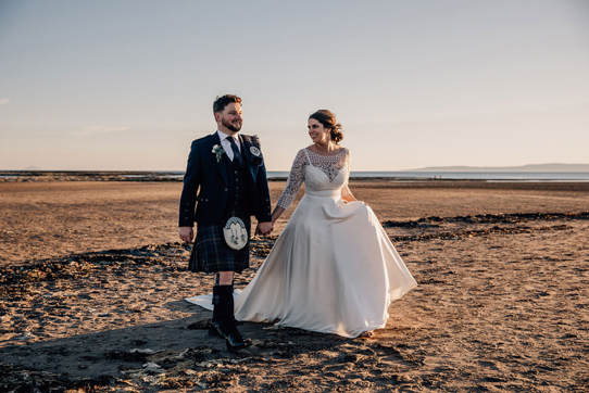 Bride and groom Walking On Beach At Troon