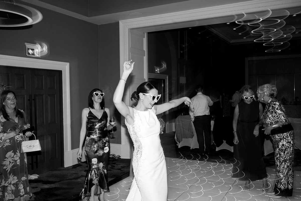 Black and white photo of the bride dancing on the wedding reception dancefloor at Clayton Hotel Glasgow.