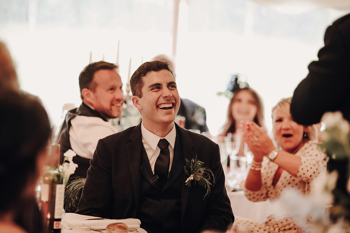 A Person Wearing A Suit Jacket And Tie Laughing