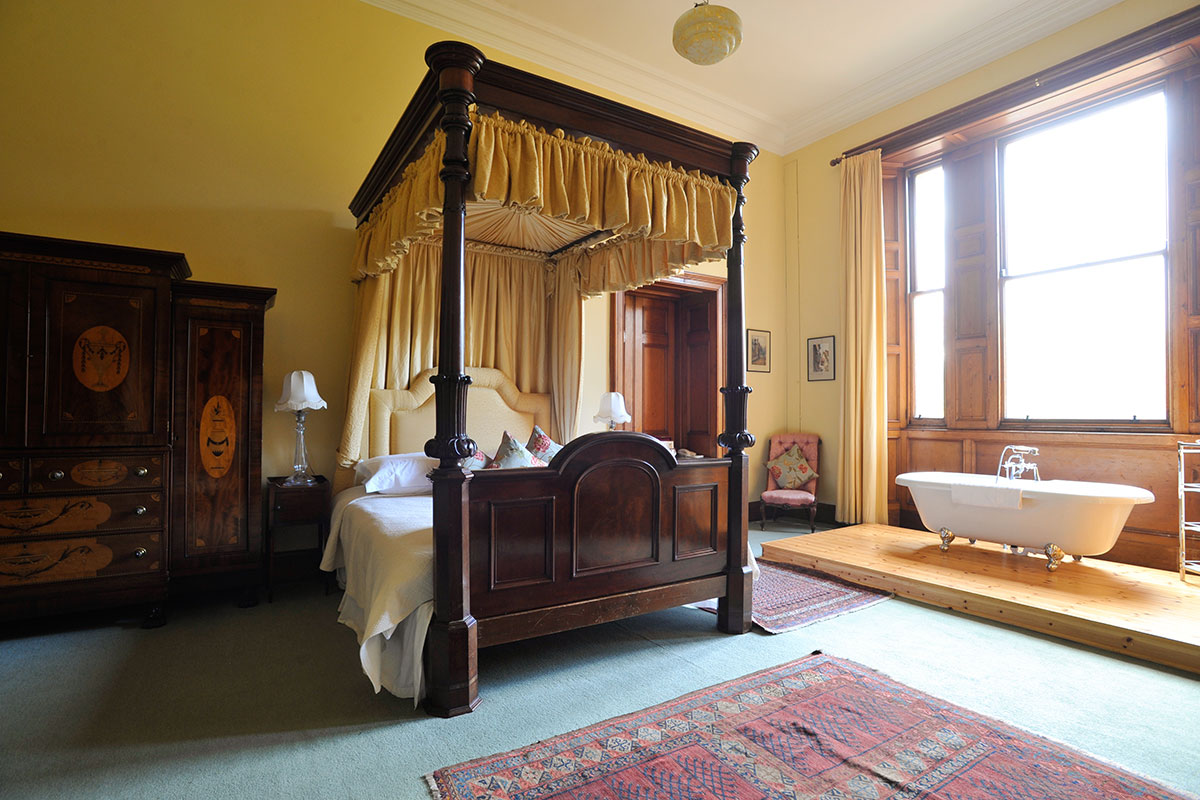 Yellow Room bedroom at Cambo Estate with four-poster bed and freestanding bath