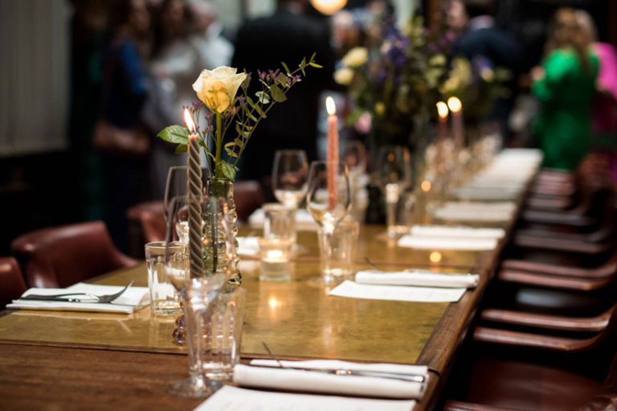 Close-up of candlelit wedding table at Hawksmoor Edinburgh with rose and glassware