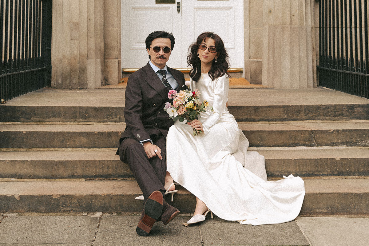 Newlywed Bride And Groom Sitting On Stairs In Edinburgh New Town