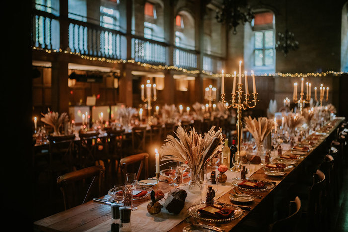 A long table with candles and flowers in the ballroom at Achnagairn Castle.