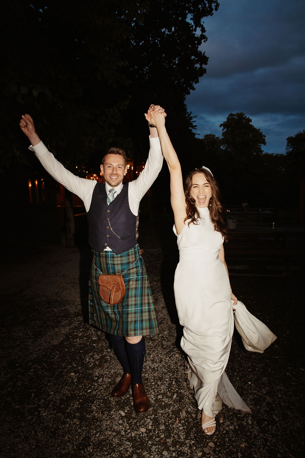 a cheering bride and groom at night outside during their Netherdale House wedding