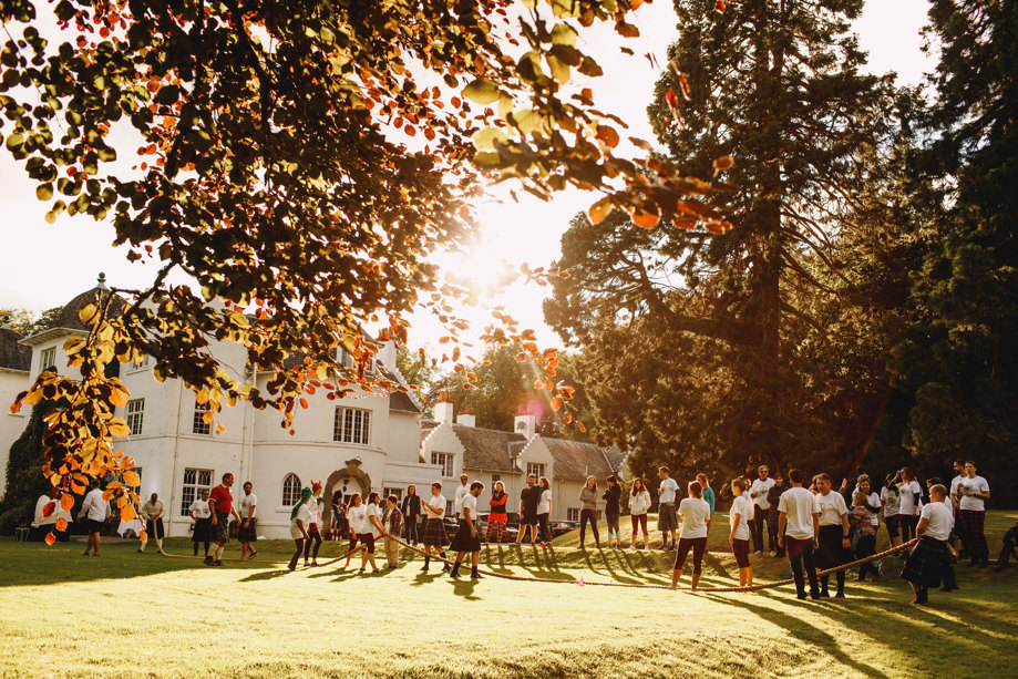achnagairn Castle exterior with guests playing tug of war in the sunshine