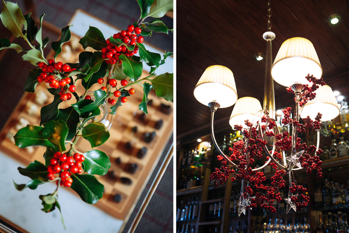 Spring of holly in a vase and red berries hanging from the light shade 