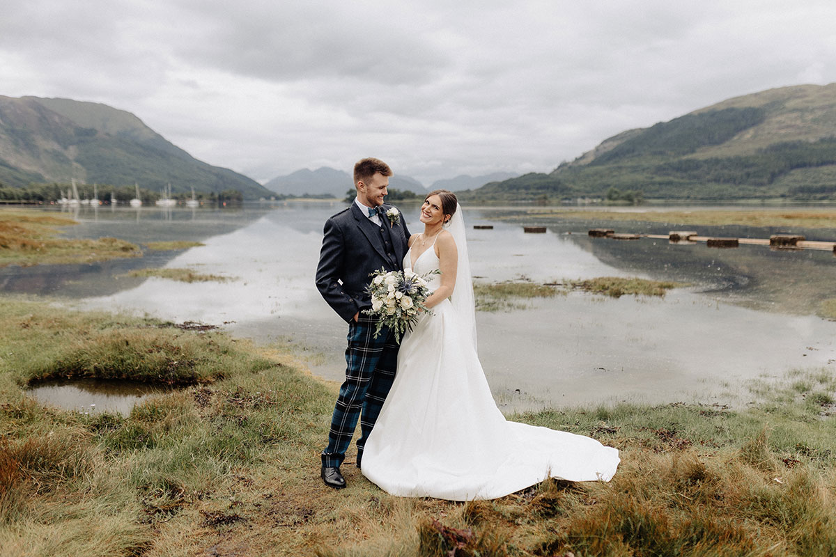 Couple standing waterside smiling