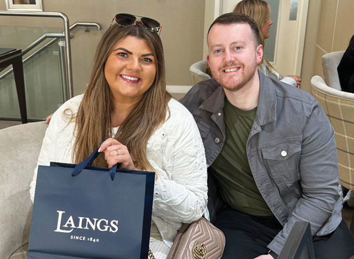 Man and woman smiling with bag with jewellery brand name