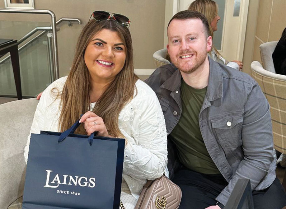 Man and woman smiling with bag with jewellery brand name