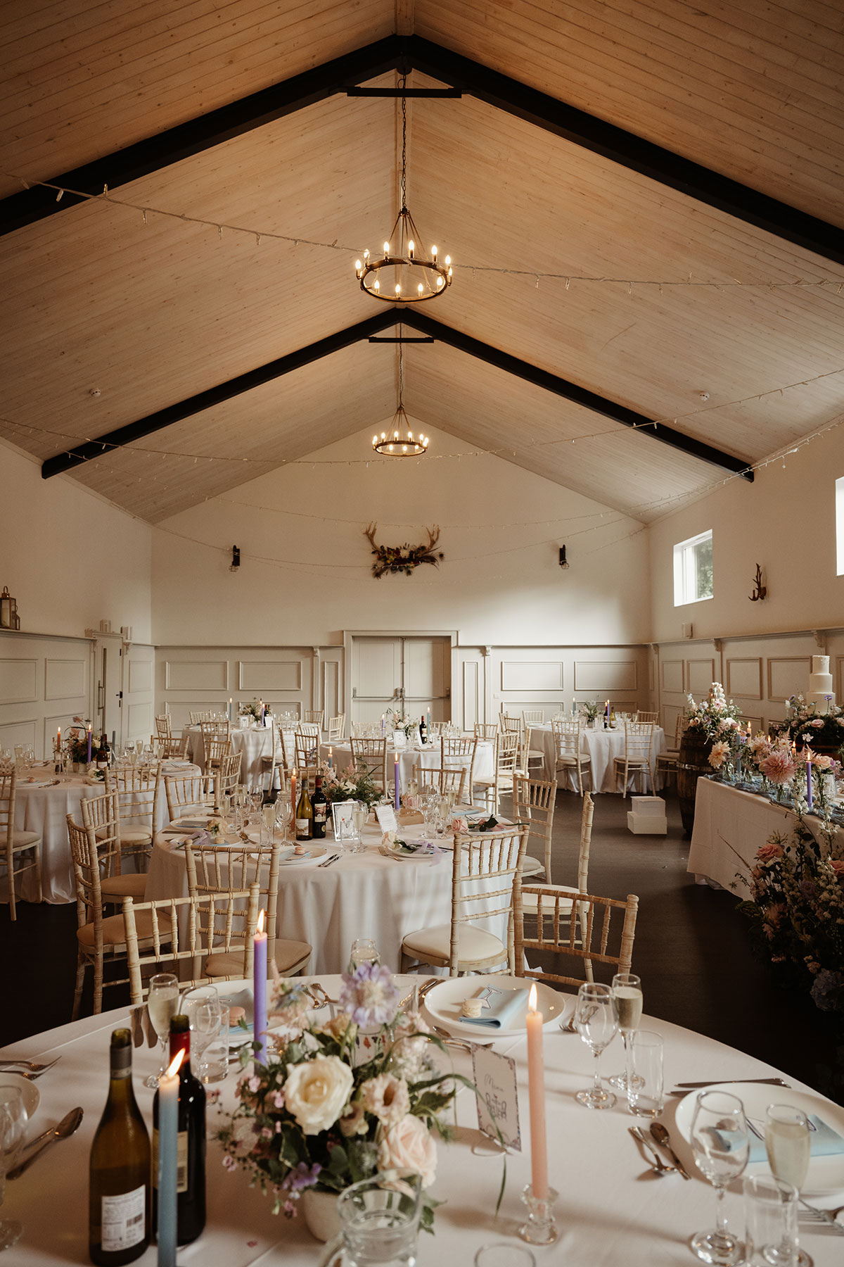 a dining room set for a wedding with round tables and Chiavari chairs and pastel wedding decor at Netherdale House