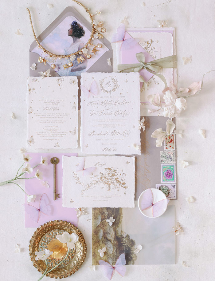 purple and butterfly themed invitation suite laid out and viewed overhead