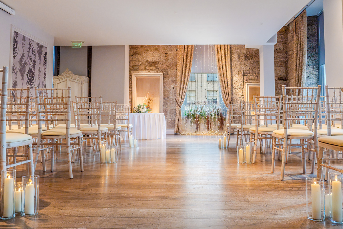Citation Aisle view of wooden chairs vases with pillar candles