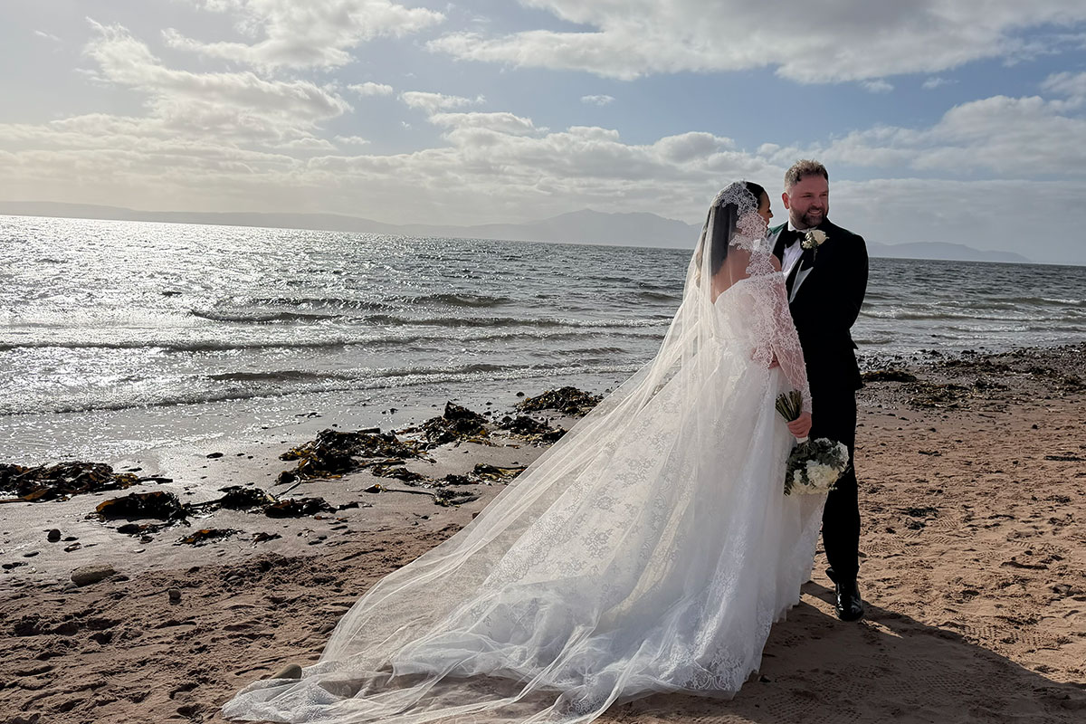 Couple standing on the beach on their wedding day
