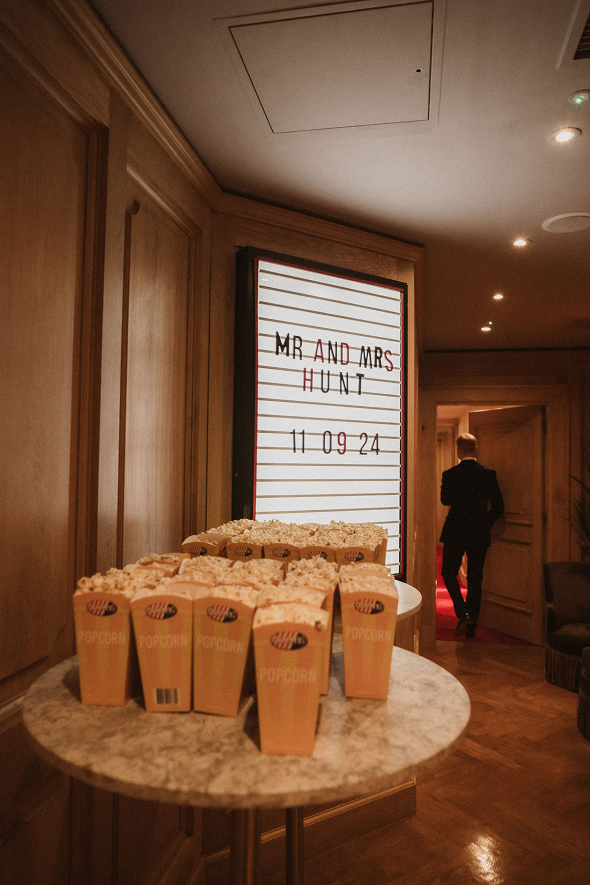 boxes of popcorn on a round table with light box sign in the background